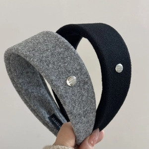 Detail of wool fabric headband with silver metal buckle and handmade label