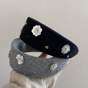 Close-up of black and grey padded headbands with sparkling rhinestone flower motifs