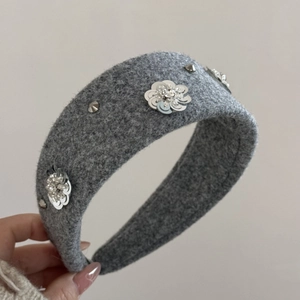 Detailed view of grey wool headband with sequin flowers and metallic studs decoration