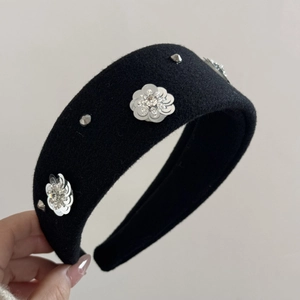 Detail of black velvet headband with sequin flower patterns and silver metallic studs