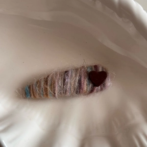 Cute heart-decorated wool yarn wrapped BB hair clip for women in a white ceramic dish