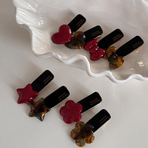 Detail view of heart and star acetate hair clips with France Handmade gold lettering