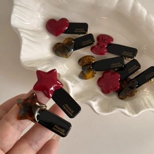 Close-up of heart and star acetate hair clips showing France Handmade gold lettering