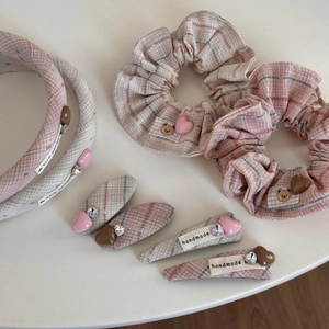 Détails des chouchous en tissu à carreaux rose et gris avec patchs d'ours mignons