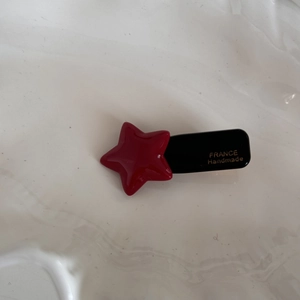 Detailed view of red star acetate hair clip with golden France Handmade engraving