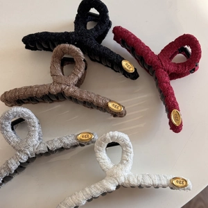 Detail of five fabric wrapped hair claws with elegant oval gold metal egg labels