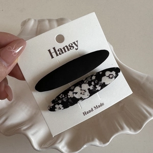Detail of floral and solid black fabric BB hair clips on a handmade display card