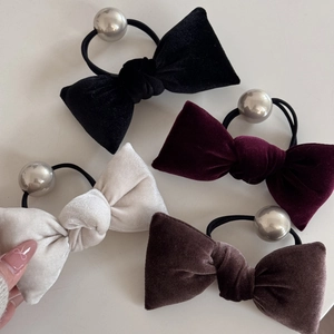 Detail of four velvet bow hair ties in black, burgundy, beige and coffee with silver beads