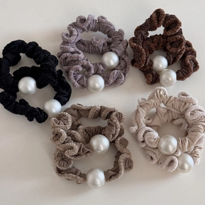 Detailed view of plush edge scrunchies with large pearls in various autumn colors