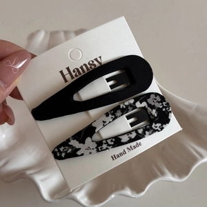 Detail of floral and solid black fabric BB hair clips on display card