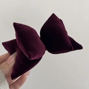 Close-up of deep purple velvet double-layered bow hair clip with luxury texture