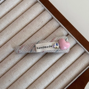 Détail de la pince à cheveux à carreaux avec cœur rose, cristal et étiquette faite main