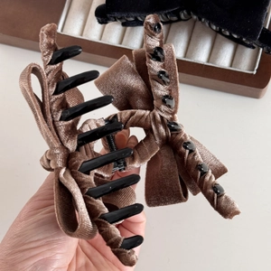 Close-up of brown velvet bow hair claw clip showing soft texture and sturdy teeth