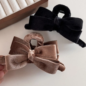 Detailed view of black and brown velvet bow hair claws with elegant layered texture