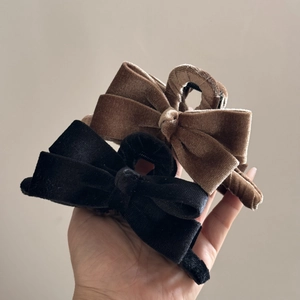 Detailed macro view showing textures of brown and black velvet bow hair claws for women