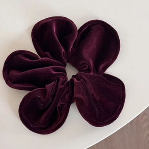 Detailed view of the dark burgundy velvet flower hair clip with a premium plush texture