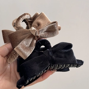 Detail showing plush velvet bow hair claws in black and brown colors with strong grip