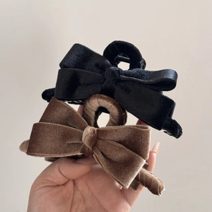 Detail of velvet bow hair claws in black and brown colors with soft texture