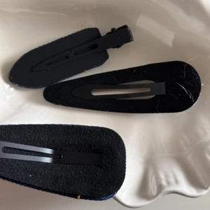 Detail view of denim hair clip backings with soft black felt and metal alligator clips
