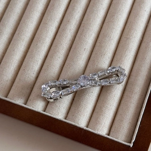 Détail d'une barrette à cheveux argentée sertie de cristaux sur plateau en velours