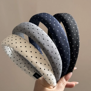 Close-up of assorted polka dot padded headbands in four colors with soft fabric texture
