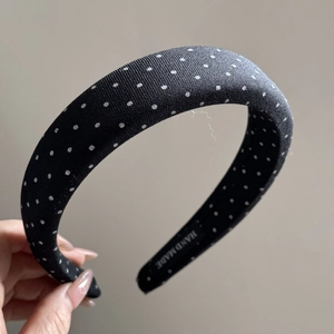 Close-up of handmade black polka dot sponge headband showing cotton fabric texture