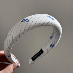 Detail of blue bow twill headband showing high-quality fabric and hand made label