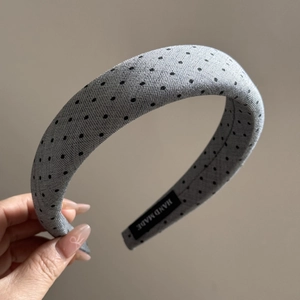 Detail of grey knitted polka dot headband with woven hand made label for hair styling
