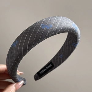 Detail showing hand made label and grey twill fabric on thick padded headband