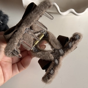 Detail of plush brown hair claw showing interior clear plastic frame and gold spring