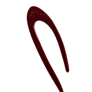 Minimalist deep red U-shaped acetic acid hair pin with gold dot details on white background