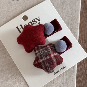Détail de pinces à cheveux étoiles en flanelle rouge et à carreaux sur support fait main