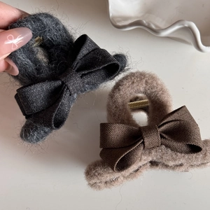 Plush fabric bow hair claw clips in dark grey and coffee colors with a soft fuzzy texture