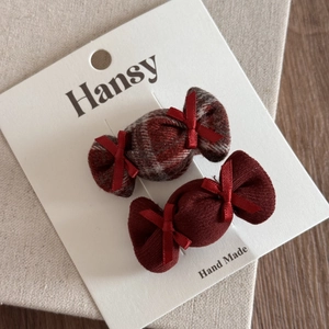 Détail de pinces à cheveux faites main en forme de bonbon avec motif écossais rouge