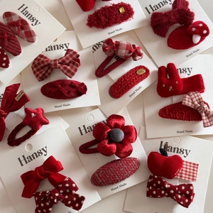 Détail de barrettes festives rouges faites main avec nœuds en velours et étoiles tricotées