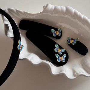 Detail of blue gradient butterfly hair accessories on elegant velvet hairpins and headband