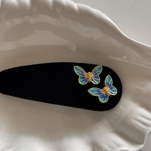 Detailed macro of vintage blue gradient enamel butterfly hair clip with gold metal accents