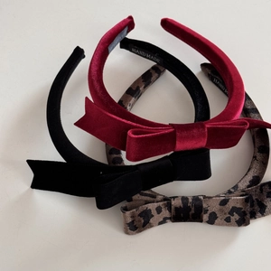 Detailed close-up of handmade velvet bow headbands in red, black and leopard print