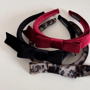 Three-piece set of velvet red, black and leopard print bow headbands on white background