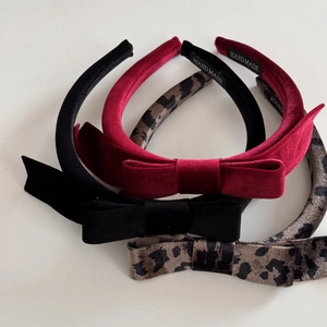 Detail of velvet bow headbands with handmade label in black, burgundy and leopard print
