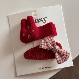 Détail de barrettes festives rouges avec lapin en tissu 3D et nœud à carreaux
