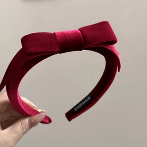 Detailed macro view of the handmade velvet bow headband with a woven black inner label