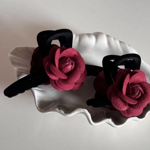 Close-up of elegant Damascus red rose hair claws on a decorative white shell tray