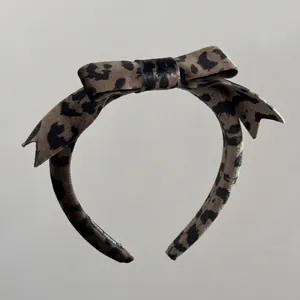 Detailed view of the velvet leopard print bow headband with textured handmade fabric