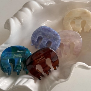 Five assorted acetate hair claws on shell tray for elegant French style hair styling