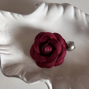 Detailed shot of dark red rose hair claw made of soft suede fabric and silver bead