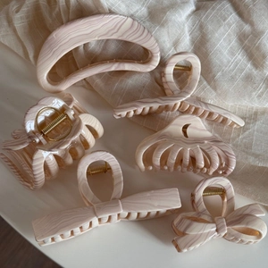 Set of large resin hair claws with pink marble texture and gold metal springs