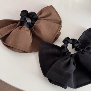 Detail of oversized striped fabric hair scrunchies in classic brown and black colors