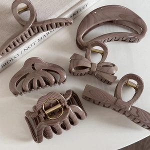 Detailed close-up of marble pattern acetate hair claw clips set in mocha purple