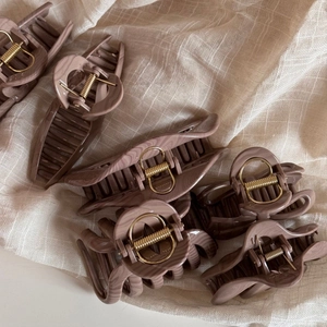 Brown marble pattern hair claw clips in various shapes on a soft linen fabric